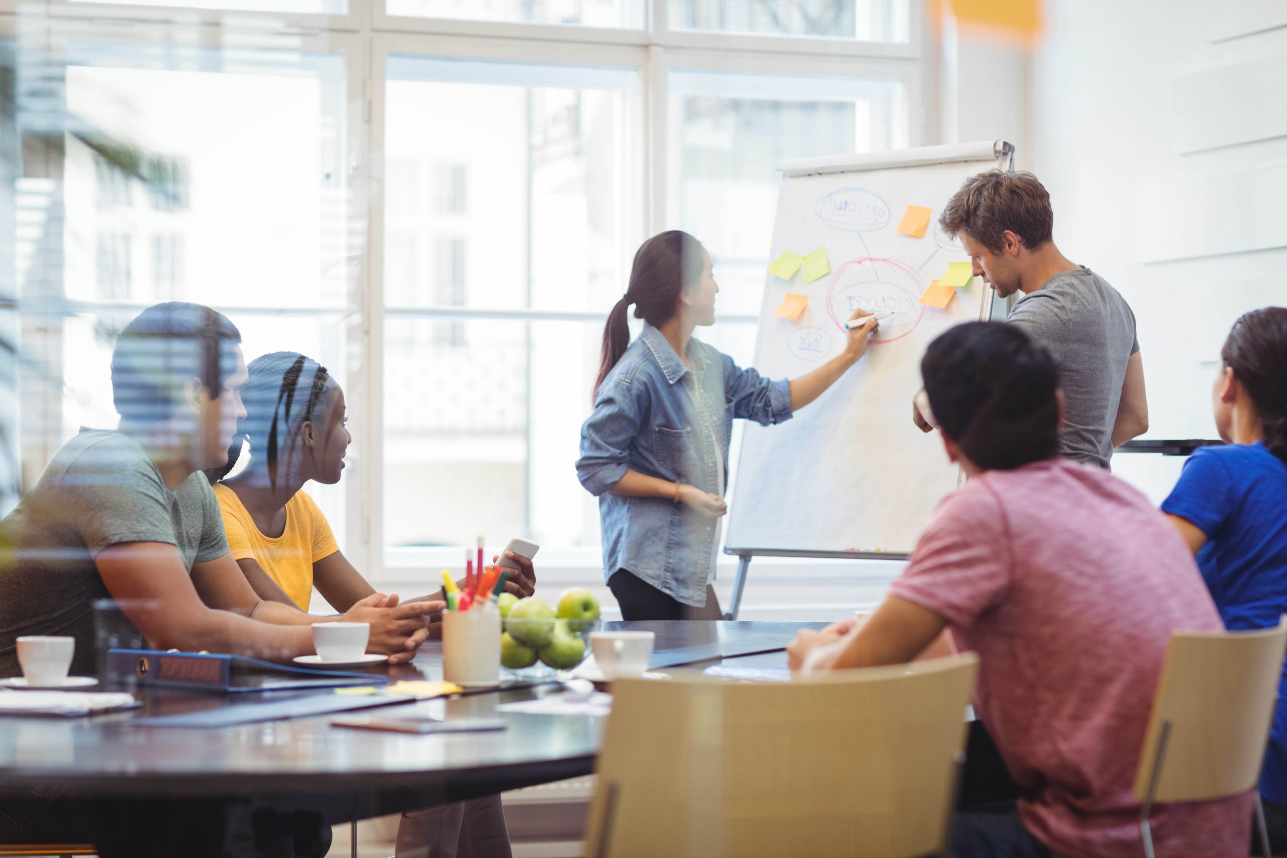 Business executives discussing with their colleagues on whiteboard
