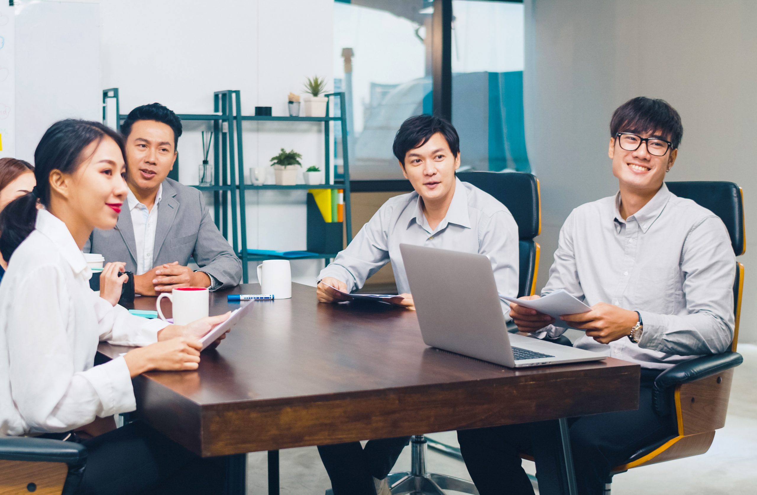 Millennial Asia businessmen and businesswomen having conference